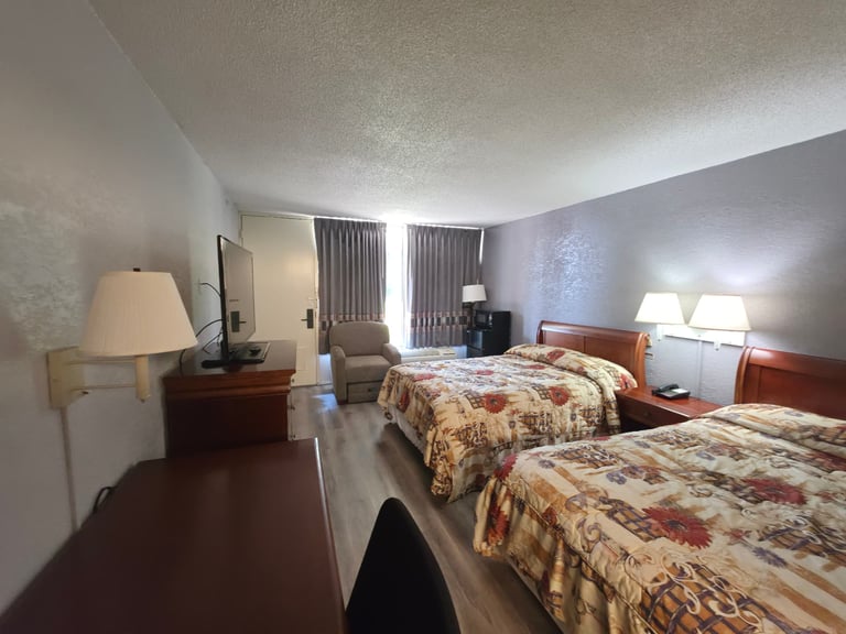 2 Beds Full Size room at Masters Economy Inn with two full beds, armchair, desk and flat-screen TV