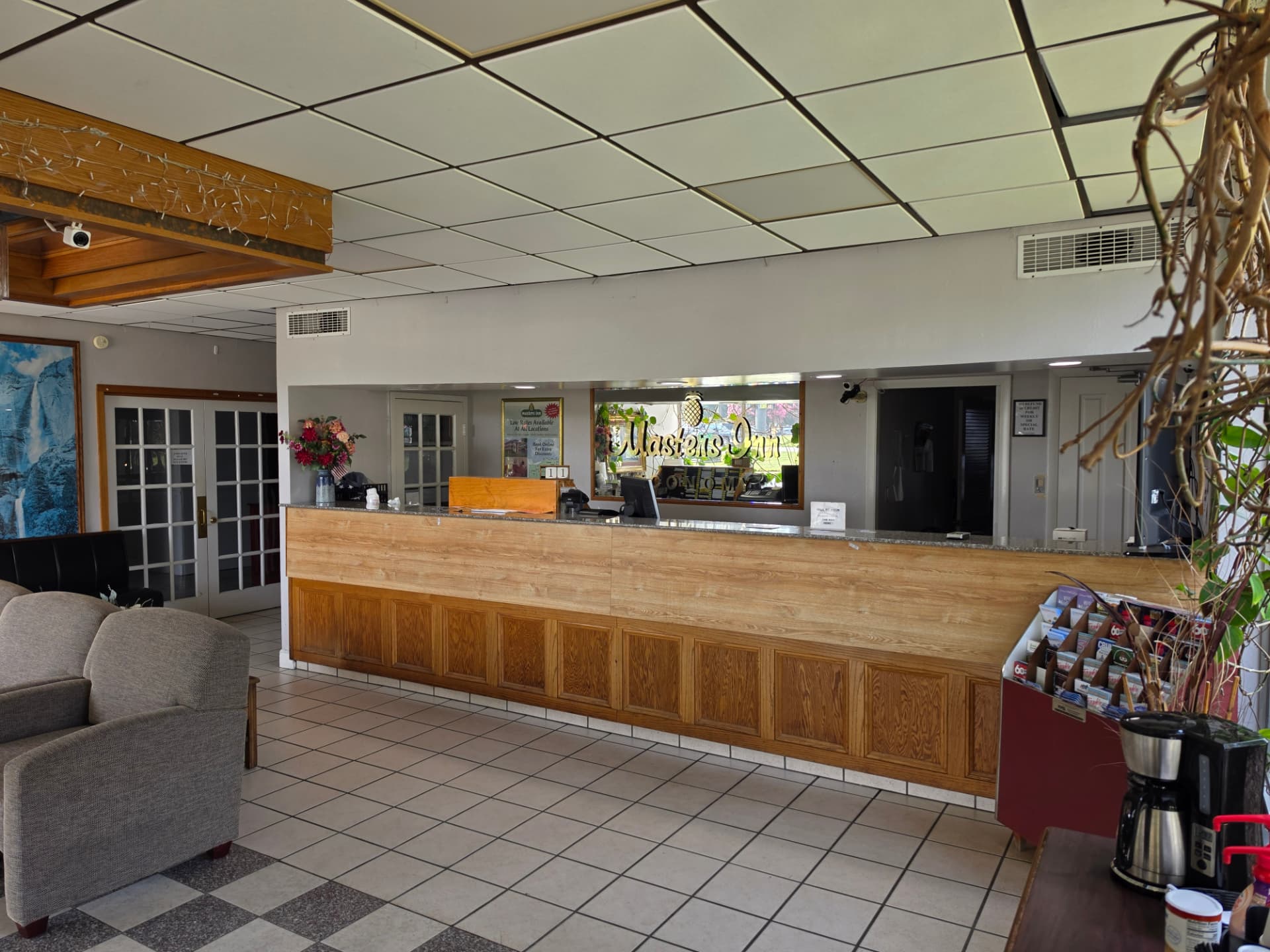The lobby of Masters Economy Inn with its long wooden front desk, seating area and coffee station