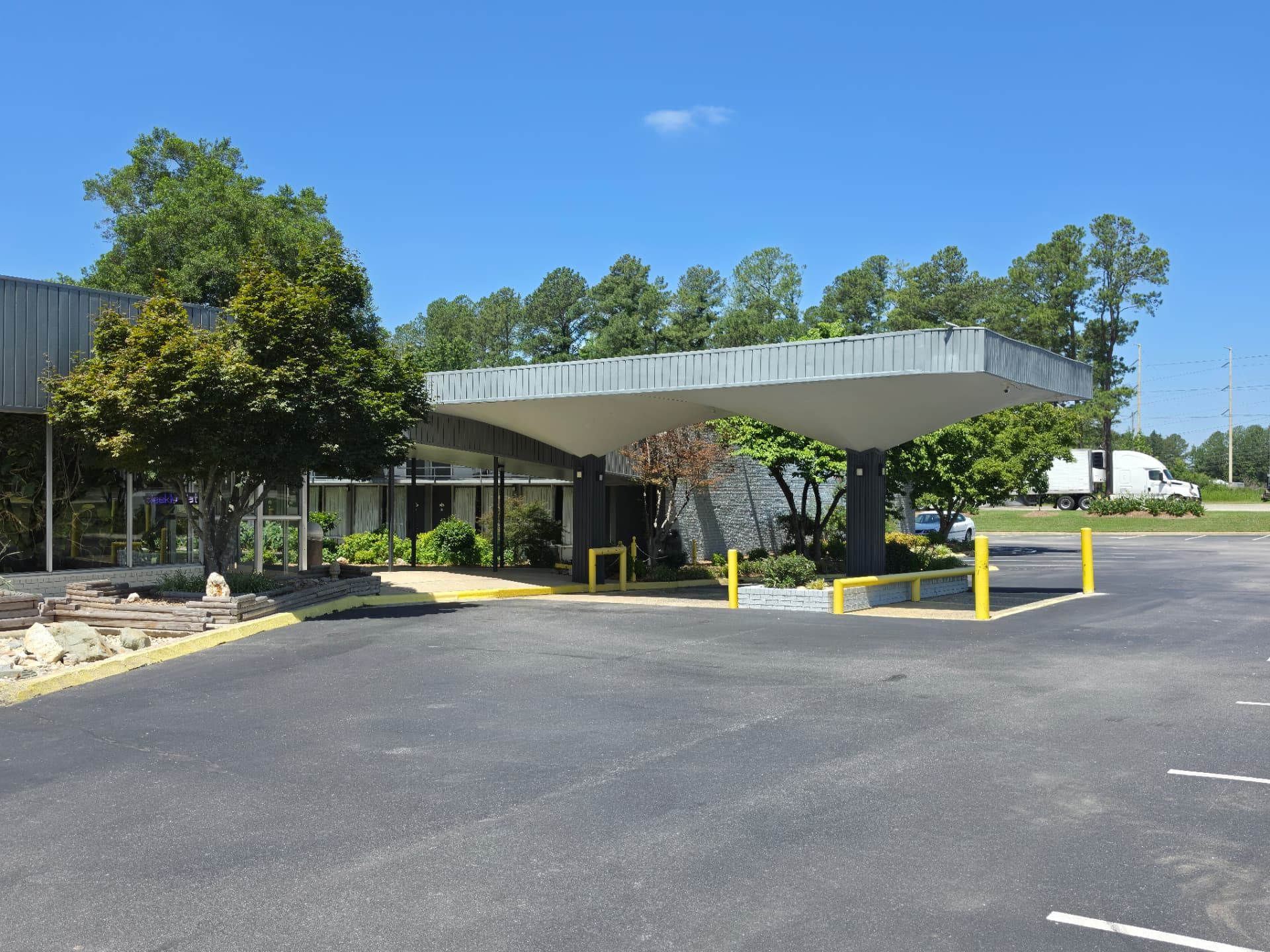 The covered drive-up canopy and front office at Masters Economy Inn, with open parking in front